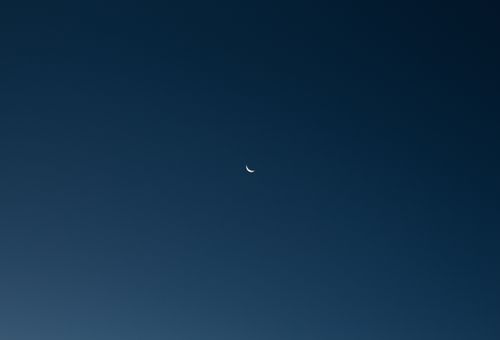 Free Crescent moon against a dark blue, minimalist night sky. Captivating celestial view. Stock Photo