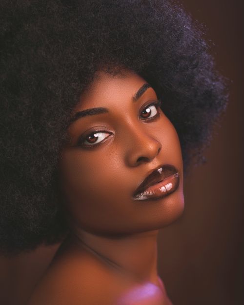 Free Artistic close-up portrait of a young black woman with afro hair, showcasing beauty and style. Stock Photo