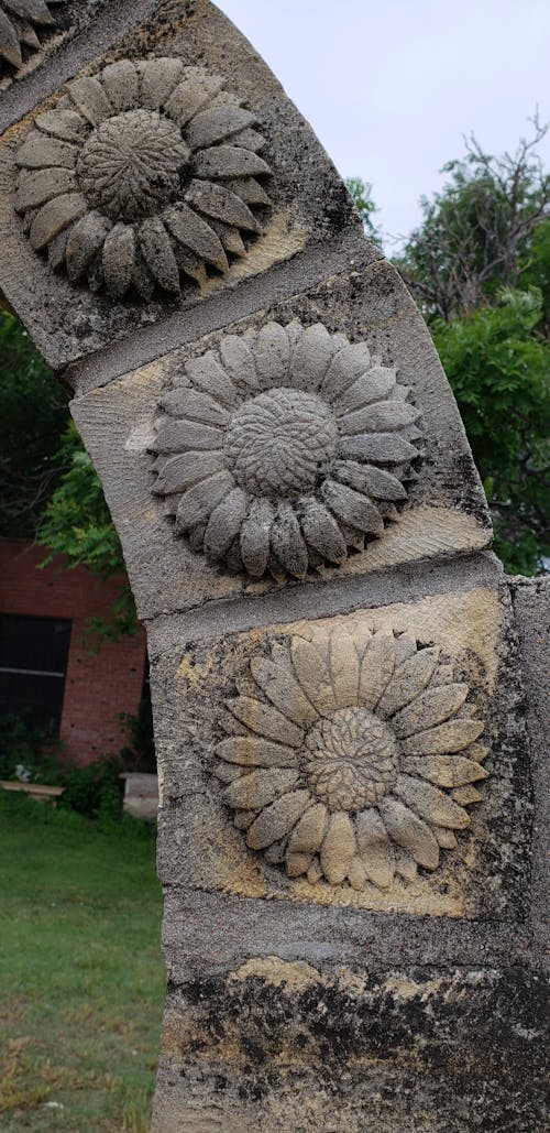 Fotos de stock gratuitas de arco de piedra con girasoles, girasol tallado en piedra, piedra con detalle de girasol