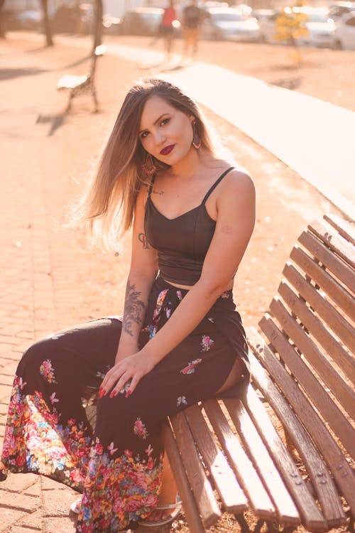 Woman Wearing Tank Top Sitting on Wooden Bench