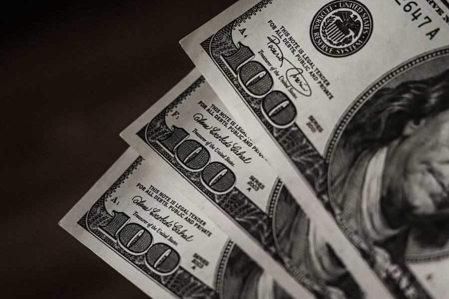 Detailed close-up image of US hundred dollar bills arranged in a fanned pattern.