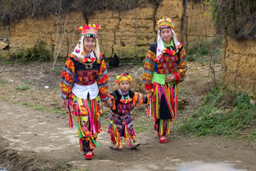 Free A Vietnamese family in vibrant traditional attire walking outdoors, showcasing cultural heritage. Stock Photo