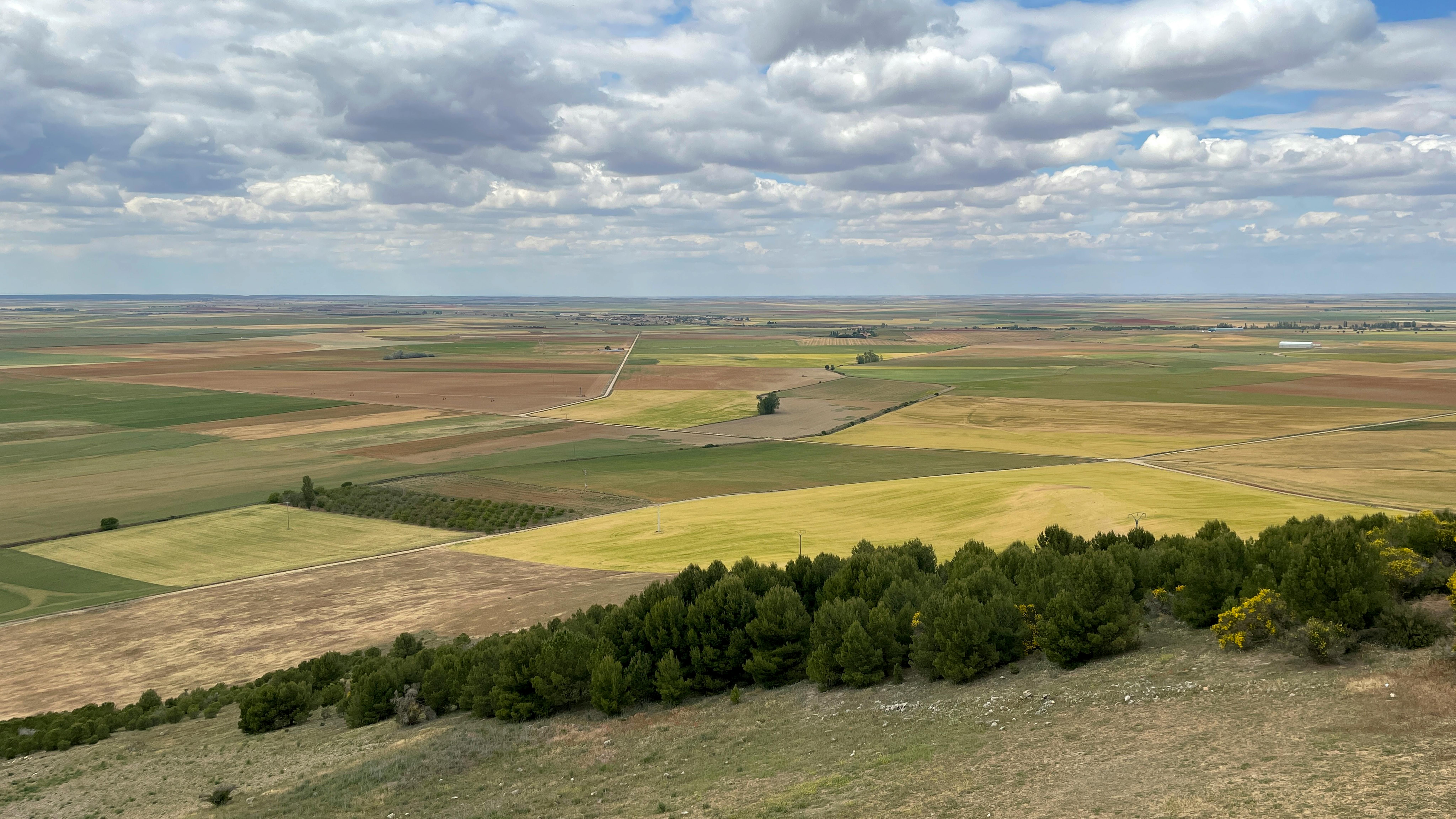 Expansive aerial view of Urueña's rural farmland, showcasing vibrant fields and open skies.
