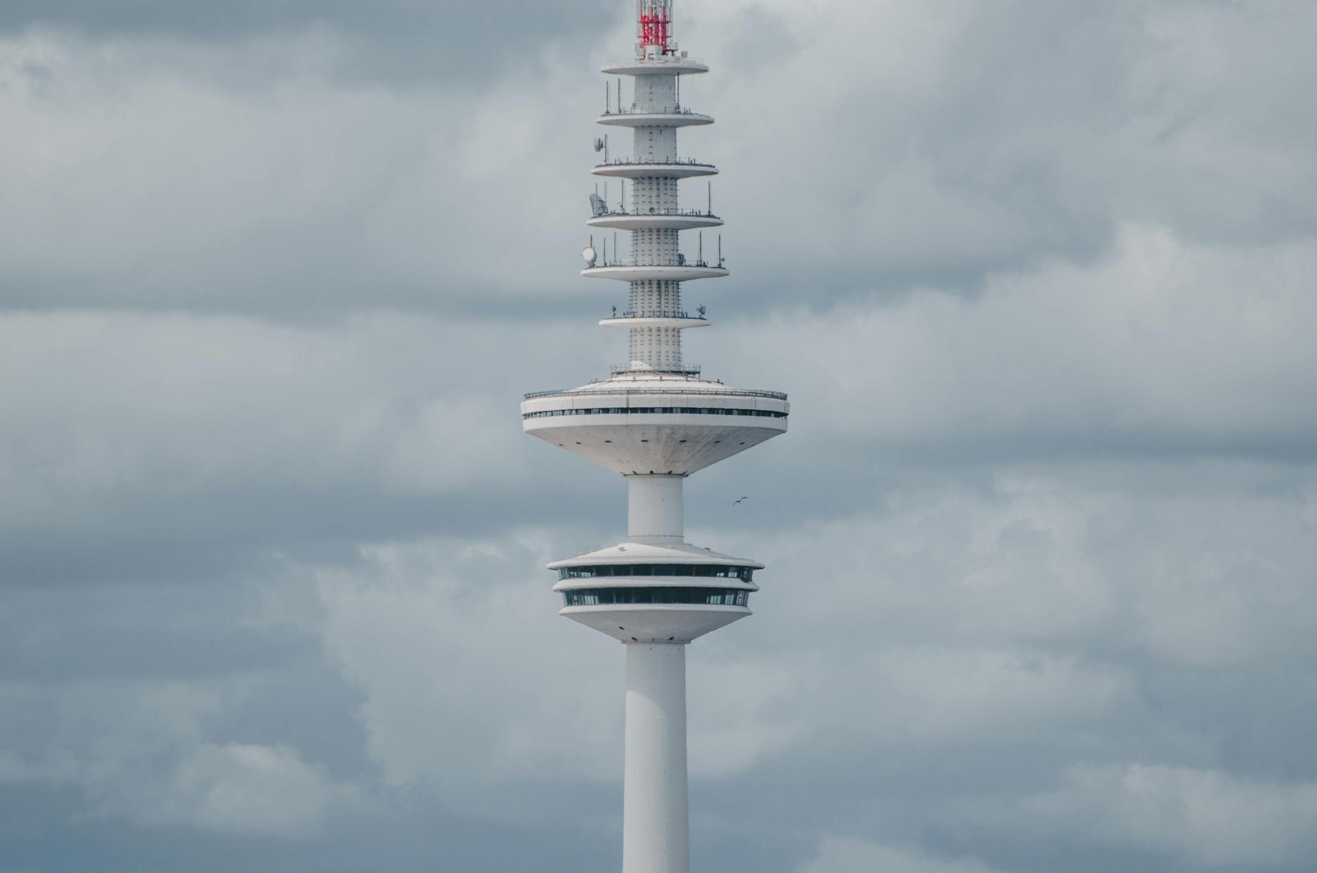 The iconic Heinrich Hertz Tower in Hamburg stands tall against a dramatic cloudy sky.
