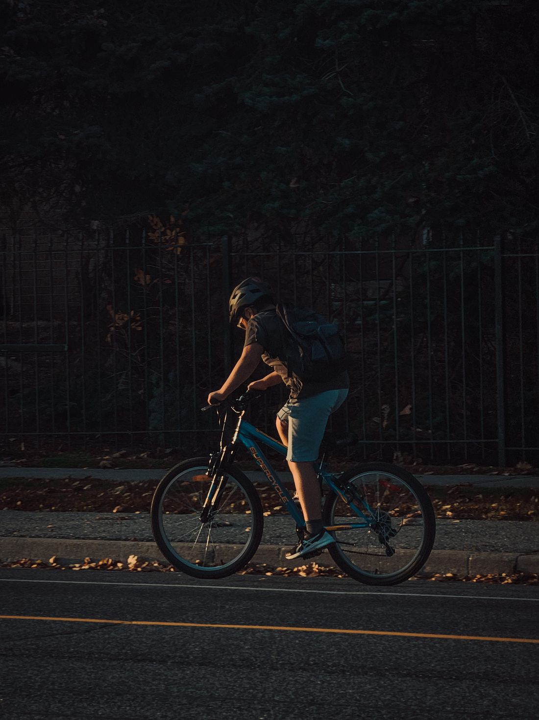 Helmeted cyclist riding a bicycle during an evening urban ride