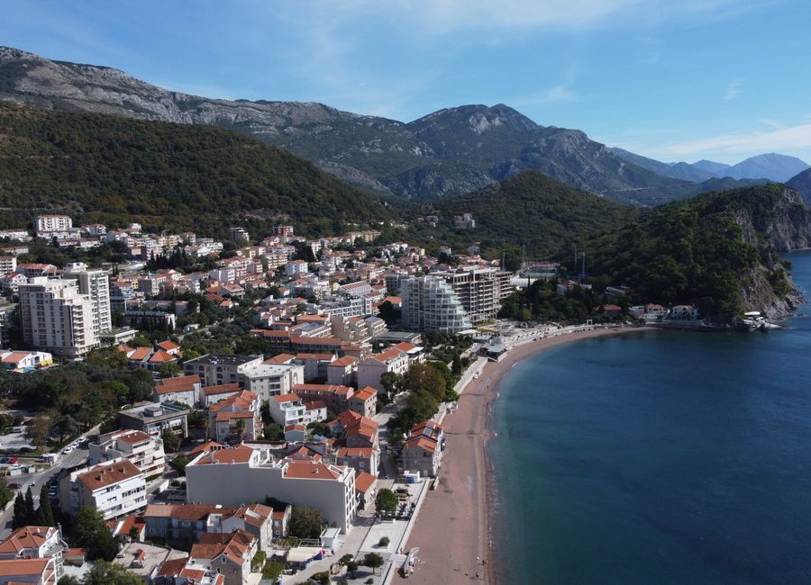 Stunning aerial view of Petrovac town and beach in Montenegro, showcasing coastal beauty.