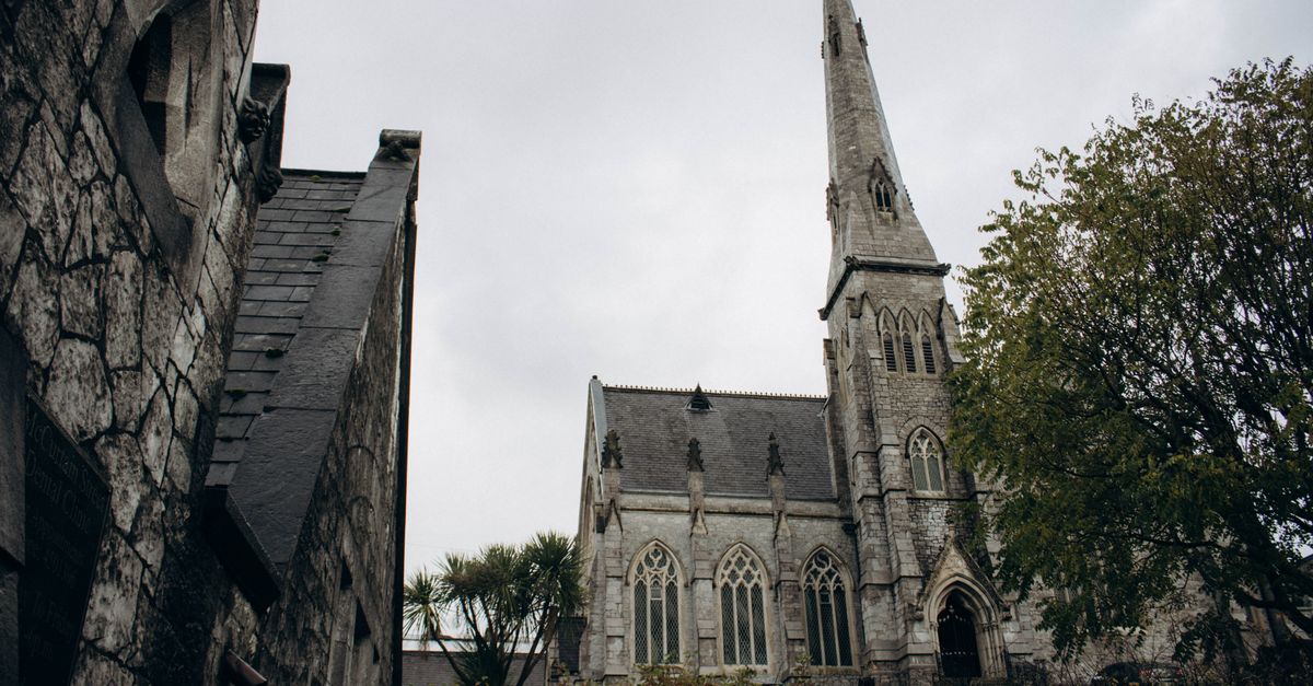 Majestic Gothic cathedral in Cork, Ireland showcasing intricate architecture under a cloudy sky.