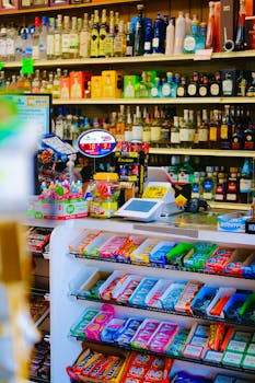 Colorful candy and liquor display in a store with a variety of sweets and beverages on shelves.