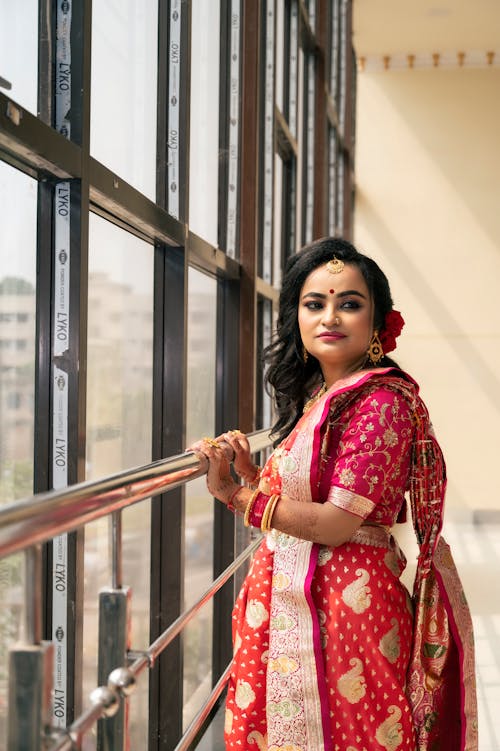 Woman in Traditional Clothing Standing near Windows