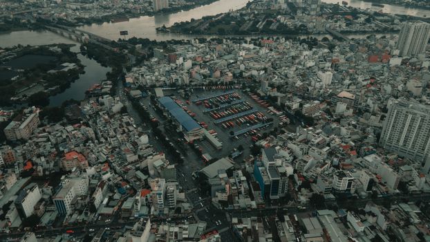 Aerial view of bustling Ho Chi Minh City showcasing dense urban architecture and riverside setting.