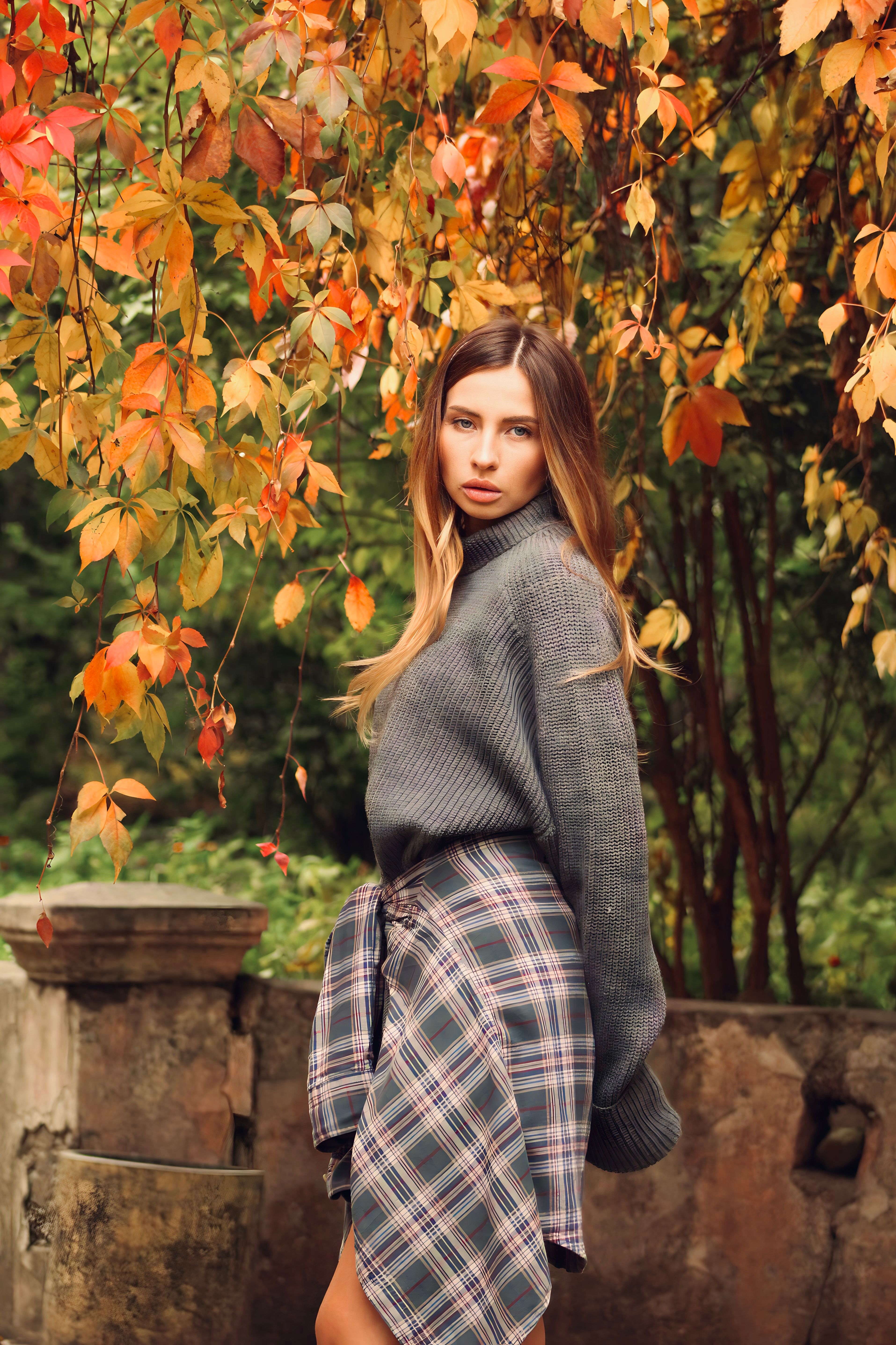 Woman in a camel sweater with a pleated skirt