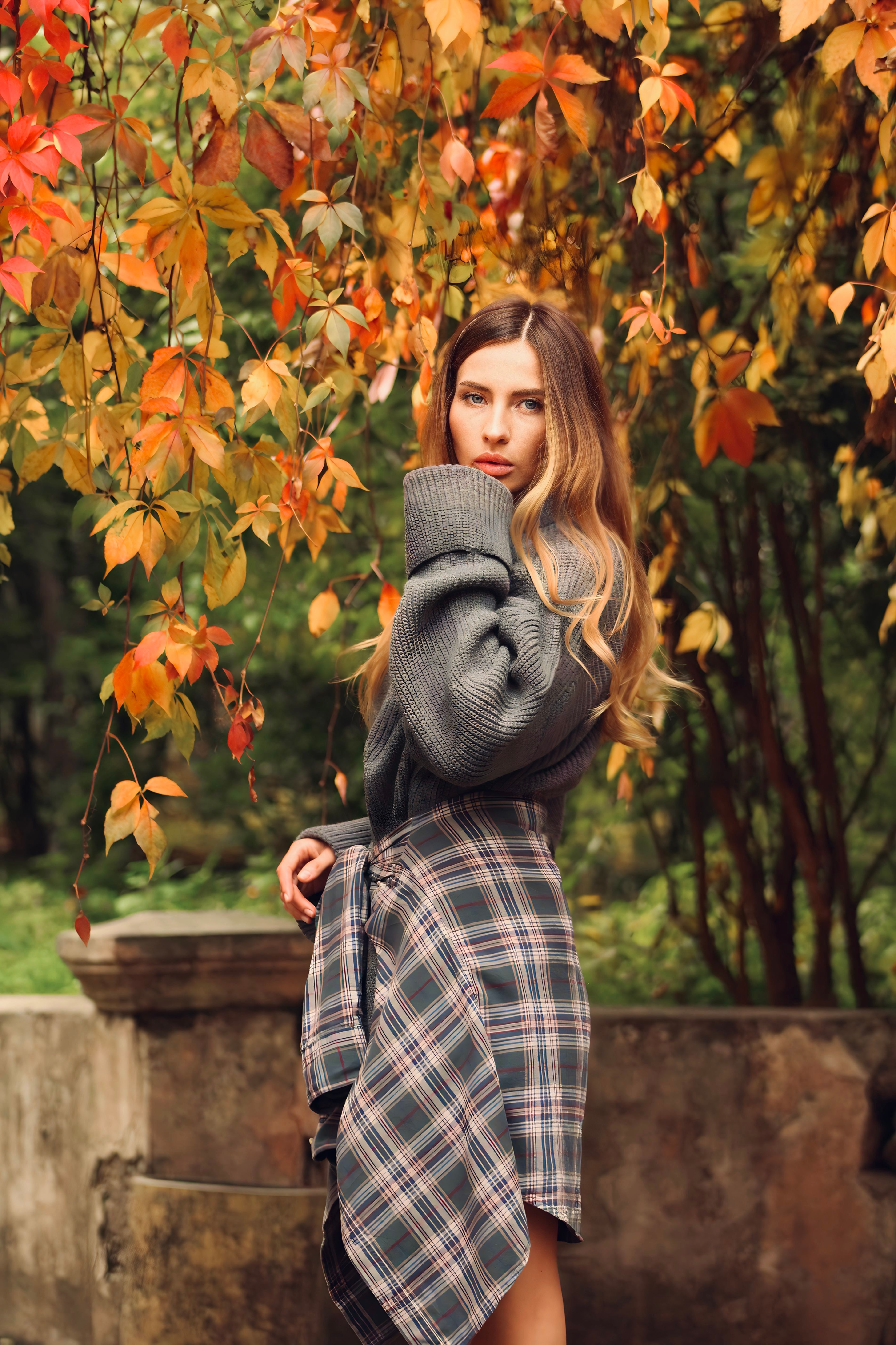 woman in cream cashmere sweater tucked into plaid mini skirt with tights