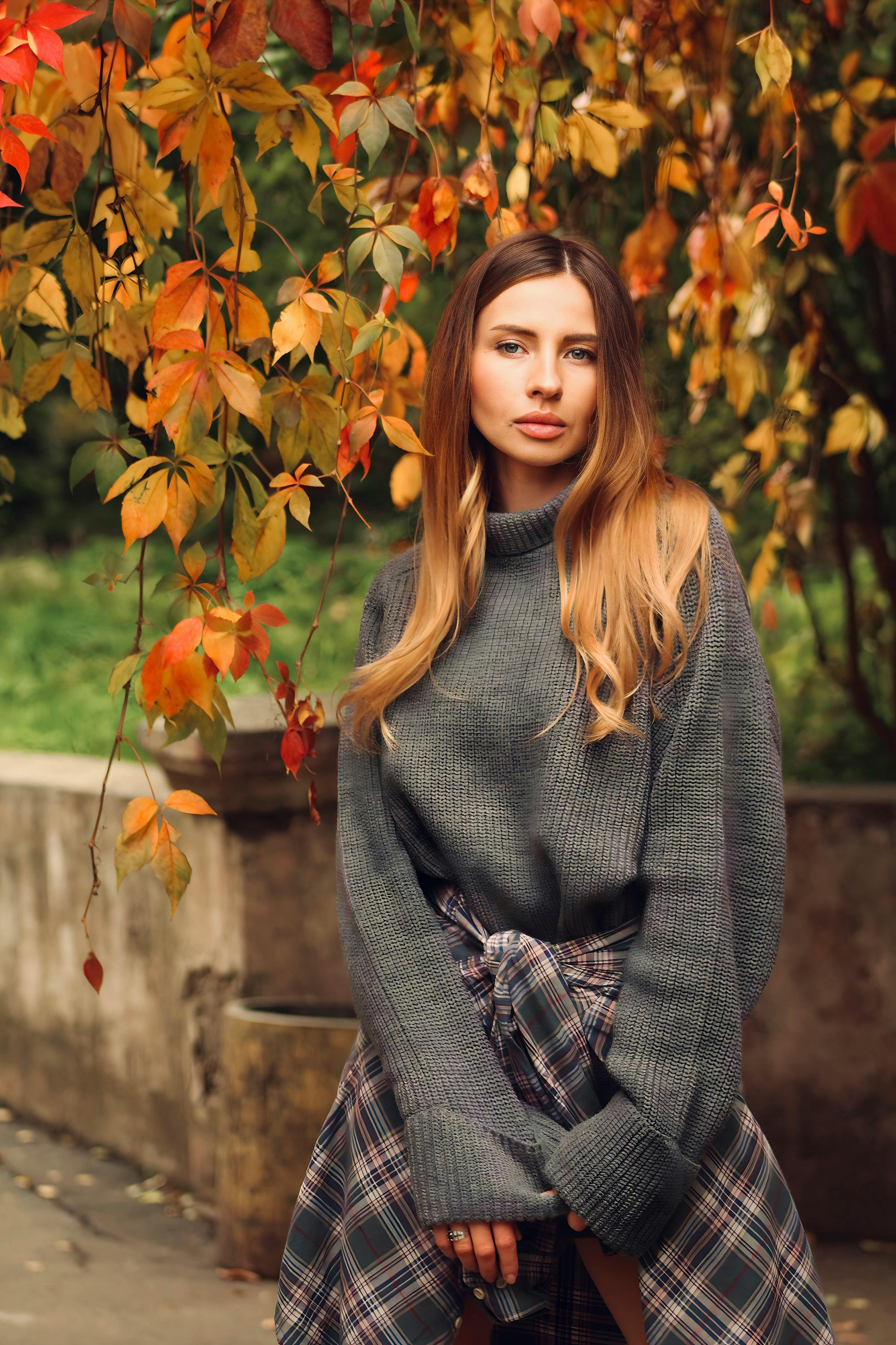 Woman in Beige Long Sleeve Coat Standing on Brown Leaves · Free Stock Photo