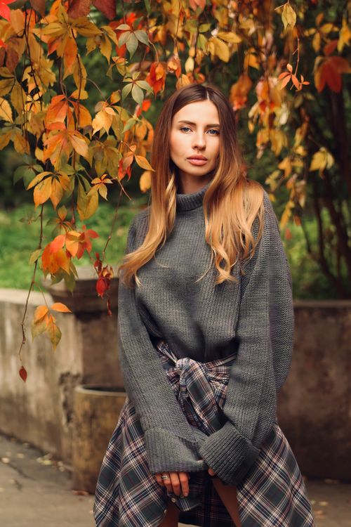 Woman in autumn outfit with plaid skirt