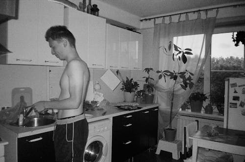 Topless Man Working in Kitchen in Black and White
