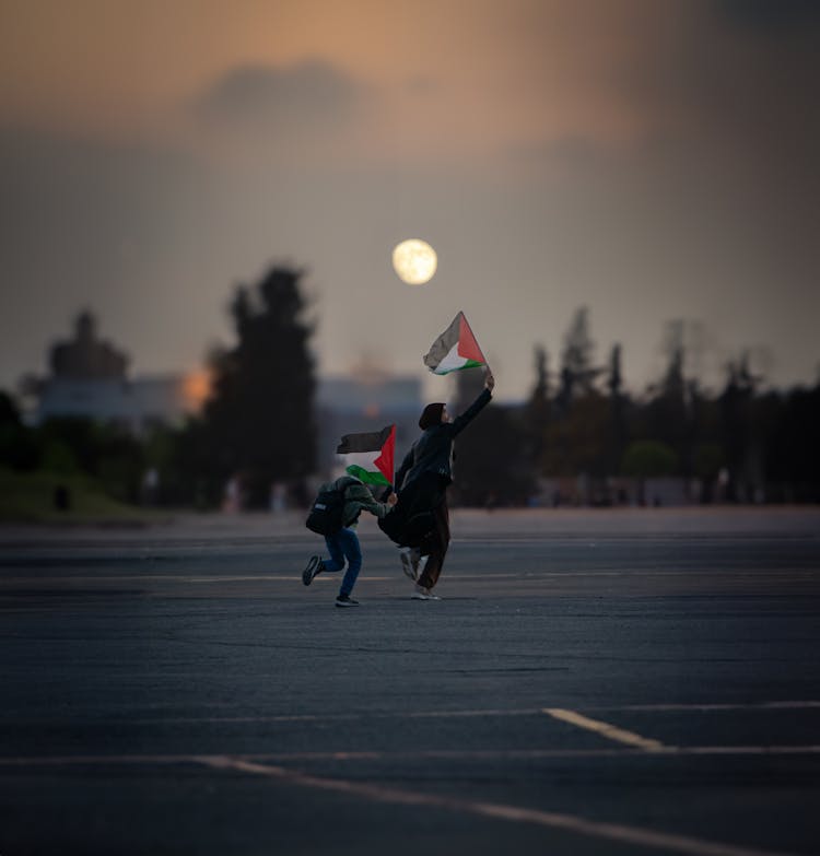 Mother And Son Running With Flags Of Palestine