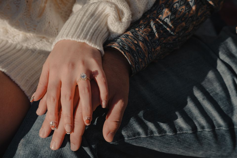 Close-up of a couple’s hands showing an engagement ring