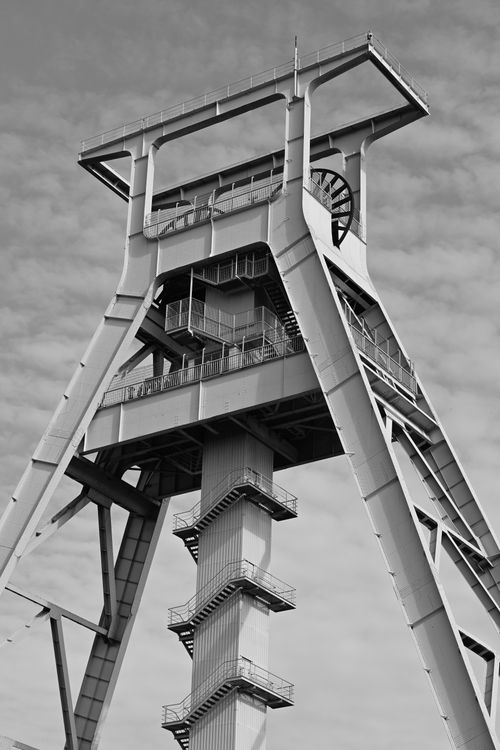 Free Black and white image of a large industrial steel structure with cloudy sky backdrop. Stock Photo