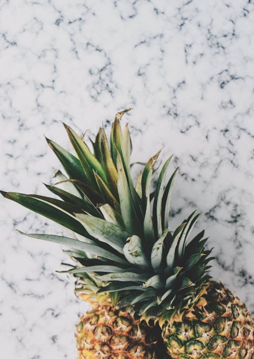 Photo De Deux Ananas Jaunes Sur Une Surface En Marbre