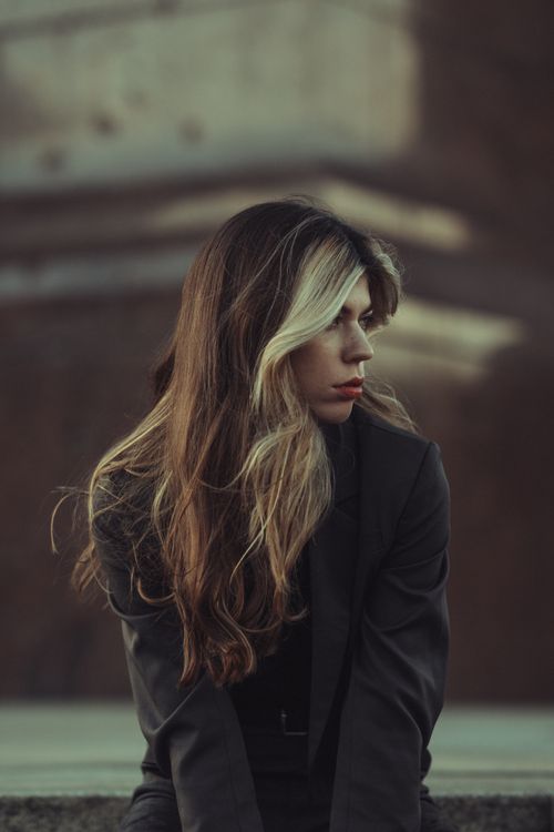 Free Portrait of a woman with long blonde hair in an elegant coat, showcasing modern fashion Stock Photo