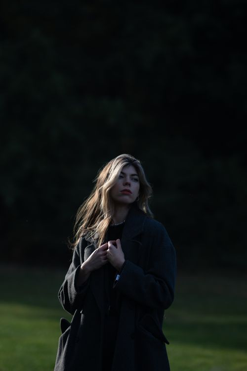 Free A woman with long blonde hair standing outside wearing a coat. Stock Photo