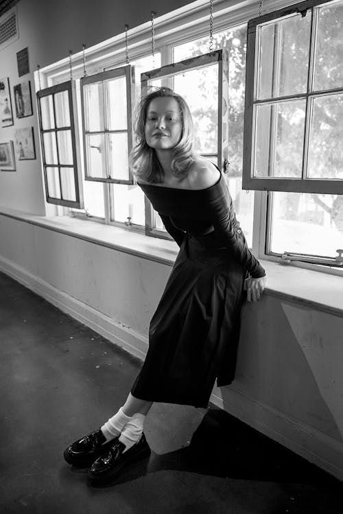 Model in Dress Standing by Windows in Black and White