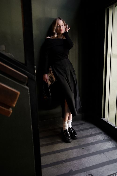 Free Stylish woman in black dress and shoes posing thoughtfully indoors. Stock Photo