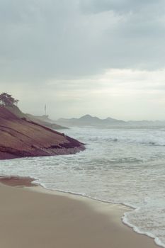Peaceful coastal scene with waves and rocky shore in Rio de Janeiro.