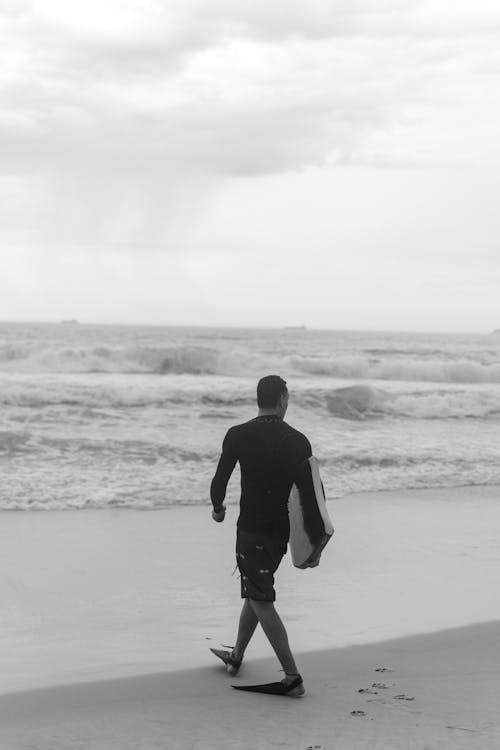 Man Walking on Beach in Black and White