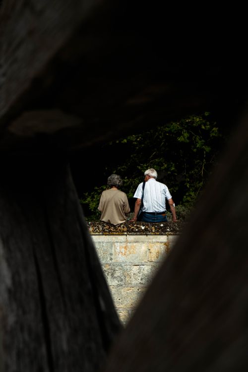 Free An elderly couple holding hands while walking through a tunnel, symbolizing love and companionship. Stock Photo