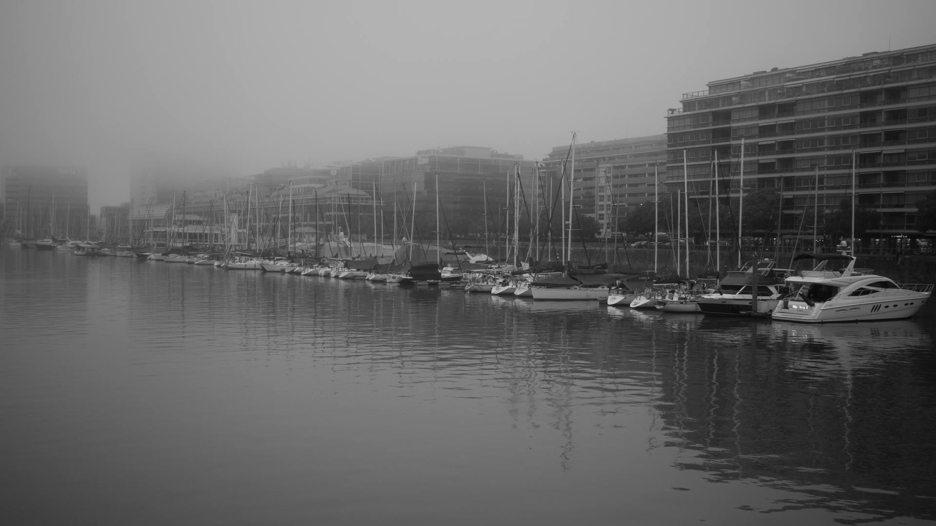 Black and white photo of sailboats docked in a foggy Buenos Aires harbor.