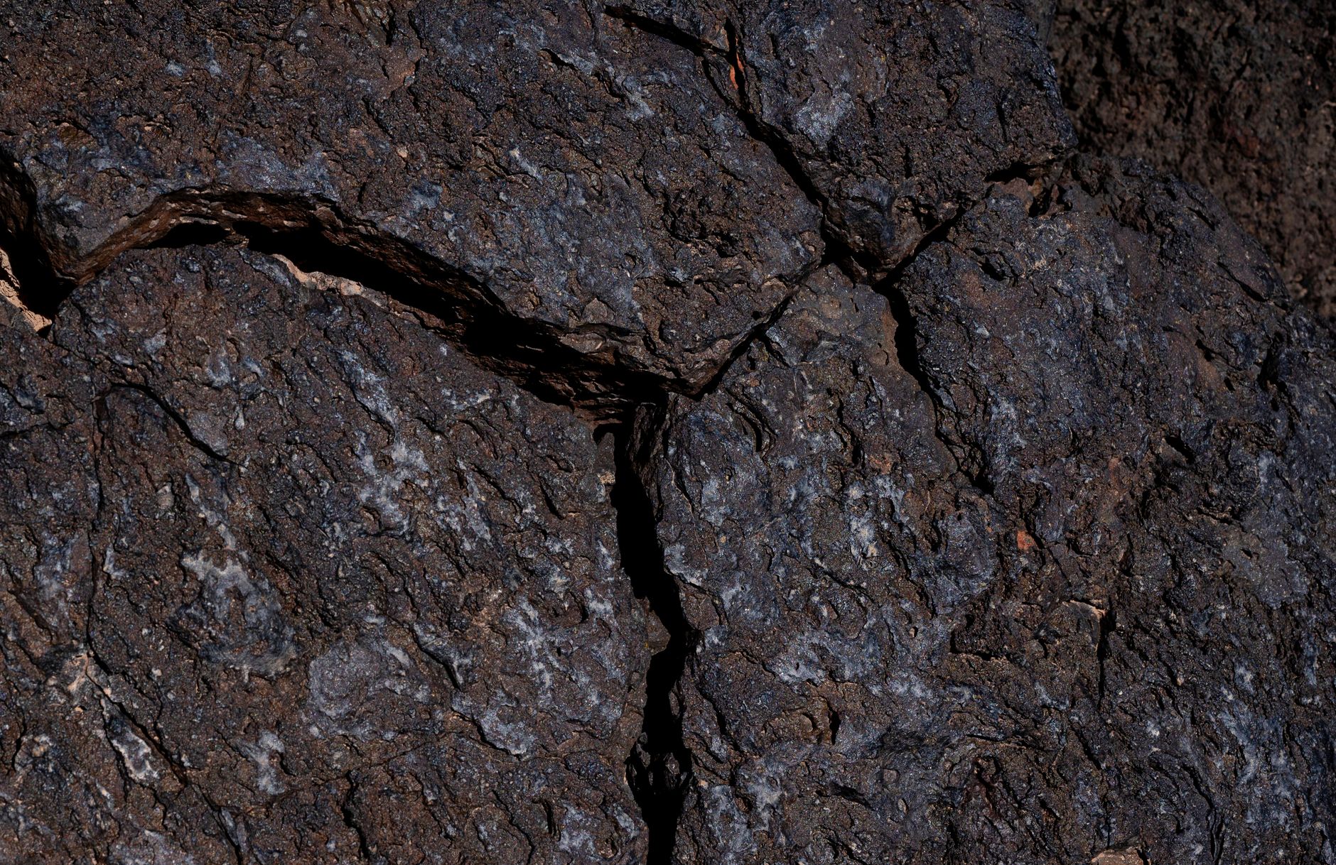 Detailed view of rugged rock surface showing natural erosion and cracks.