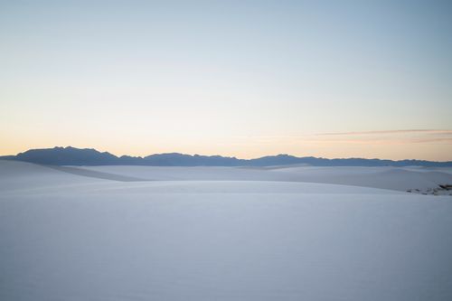 Free Expansive snowy plains with distant mountains at sunset, capturing the essence of winter tranquility. Stock Photo