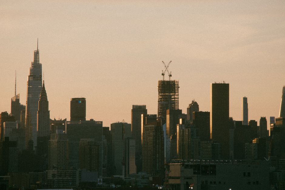 Skyline of New York City at sunrise featuring iconic skyscrapers including the Chrysler Building and One Vanderbilt.