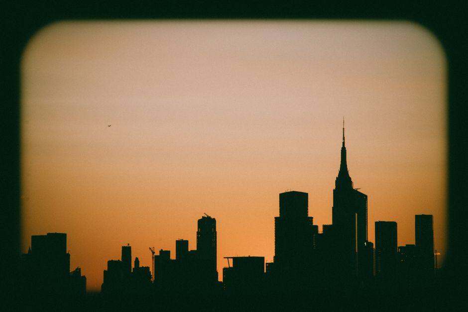 A breathtaking silhouette of the New York City skyline against a golden sunset sky.