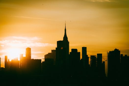 Silhouette of New York City skyline with Empire State Building at sunset.