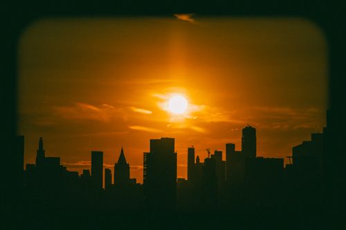 Free Silhouette of New York City skyline against a vibrant sunset, capturing urban beauty. Stock Photo