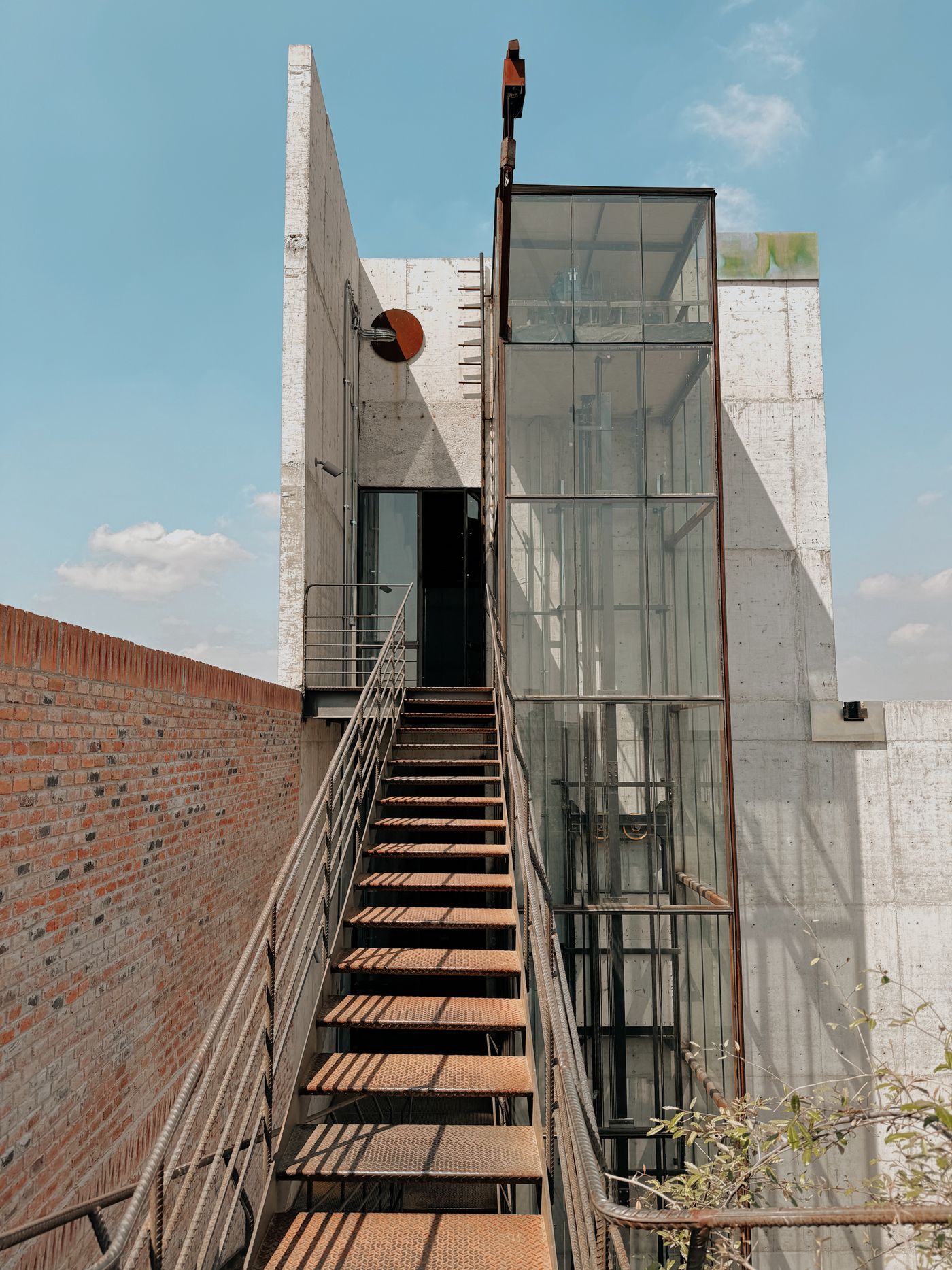 Glass elevator shaft fitted beside an existing building staircase
