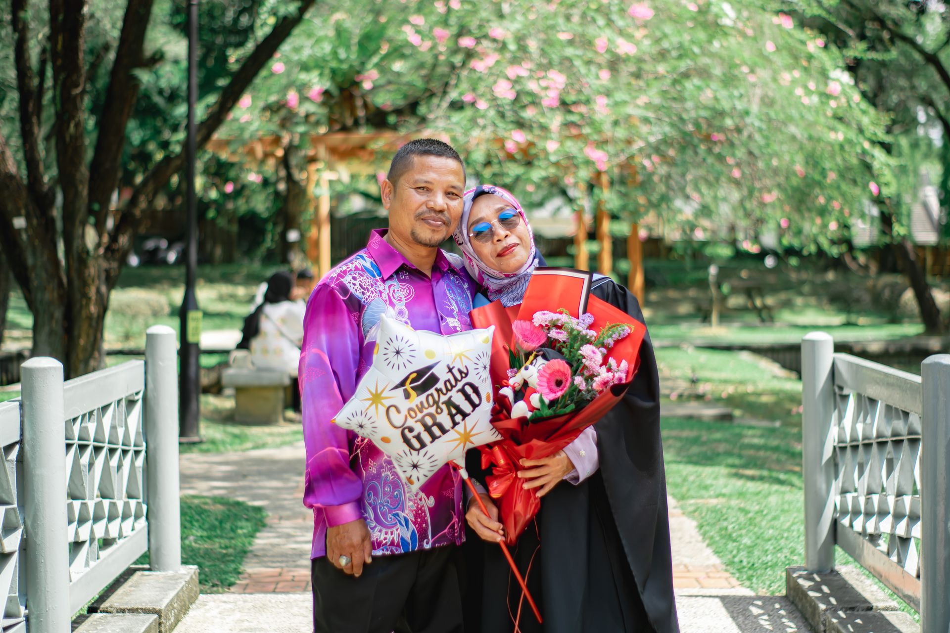 Happy moment captured of a couple celebrating a graduation in Shah Alam park, Malaysia.