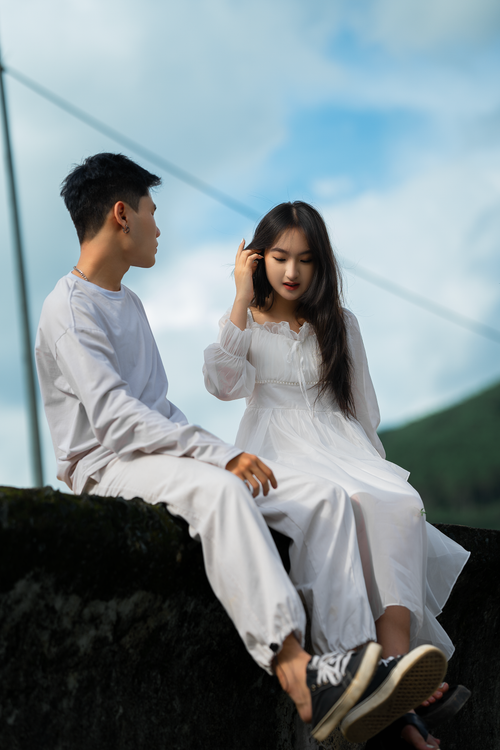 Free Young couple in white attire sharing a moment outdoors in Dalat, Vietnam. Stock Photo