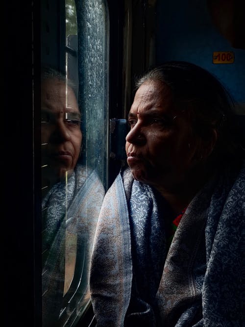 Elderly Woman in Shawl Sitting by Window