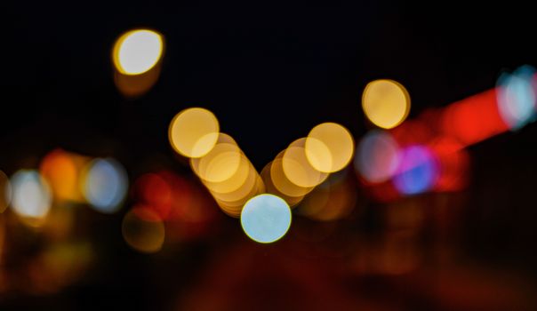 Beautiful bokeh lights create an abstract and colorful pattern in the dark night.