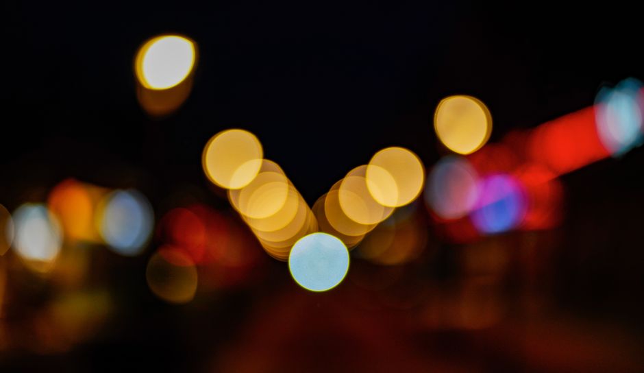 Beautiful bokeh lights create an abstract and colorful pattern in the dark night.