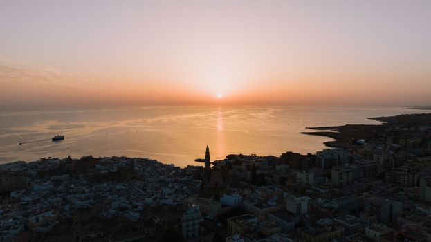 Stunning aerial sunset view over Monopoli, Puglia, Italy with coastal scenery.