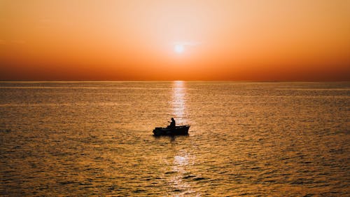 Fisherman on Boat During Sunset