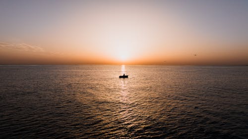 Person on Boat Alone on Ocean at Dusk