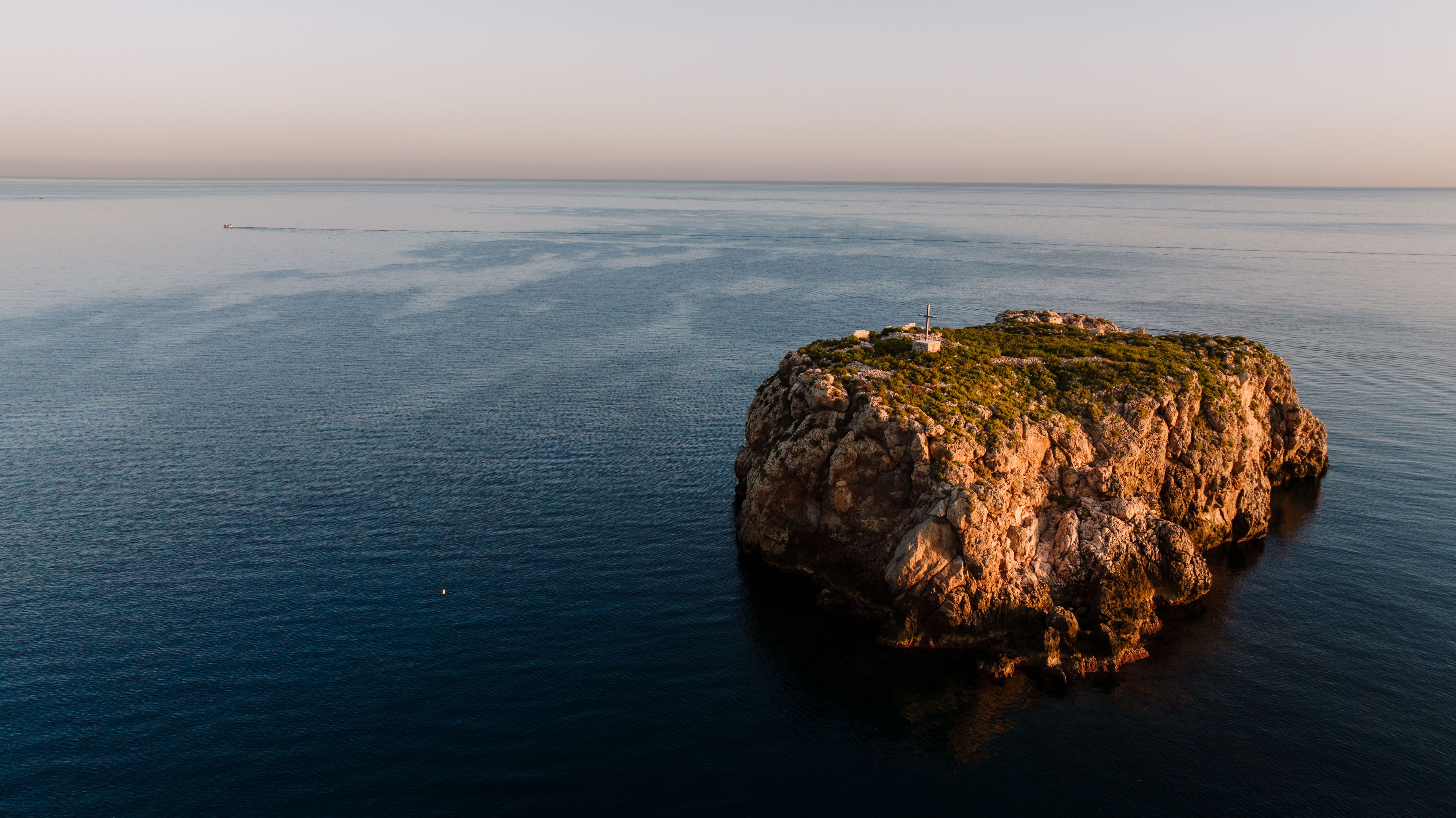 Aerial shot of Scoglio Dell Eremita islet in Polignano a Mare, Italy showcasing natural beauty.