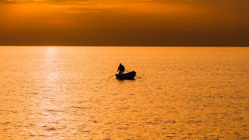 Man in Rowboat at Golden Hour