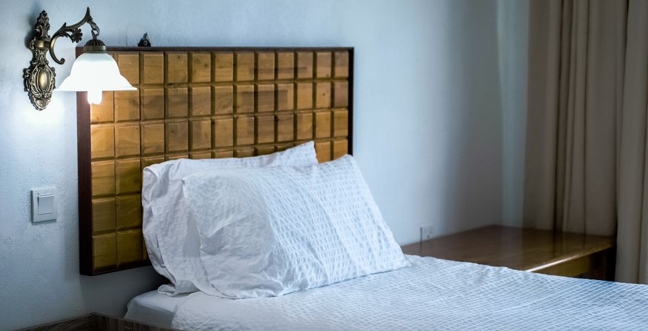 A bed with a wooden headboard — the headboard and frame are prime bed bug hiding spots