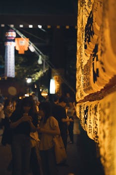 Night scene at Yasukuni Shrine with illuminated lanterns during a traditional Shinto festival in Tokyo.